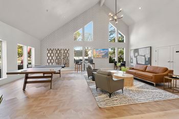 A modern living room with a pool table and a large window.
